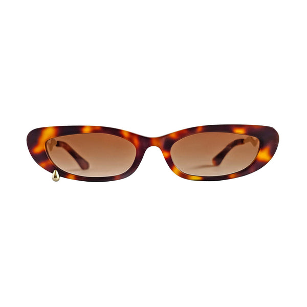 Tortoiseshell cat-eye sunglasses with brown gradient lenses and a small gold metal tip on the left frame, shown against a plain white background.